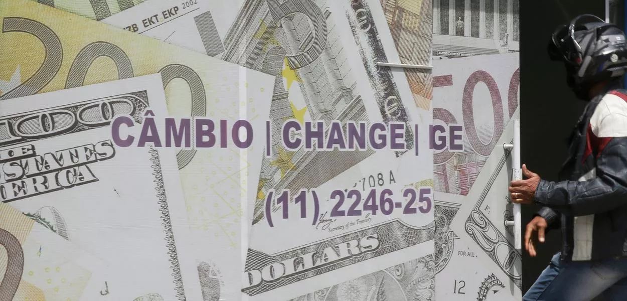 Entrada de casa de câmbio em São Paulo decorada com imagens de notas de dólar e euro 
