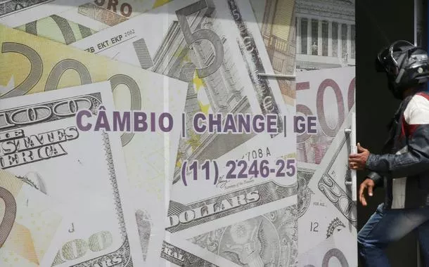 Entrada de casa de câmbio em São Paulo decorada com imagens de notas de dólar e euro 
