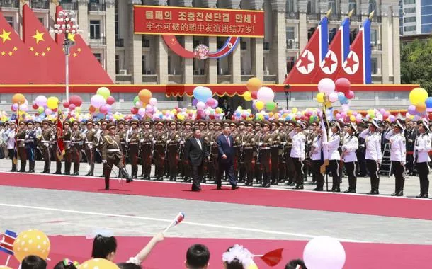 Kim Jong Un e Xi Jinping passam as tropas em revista 