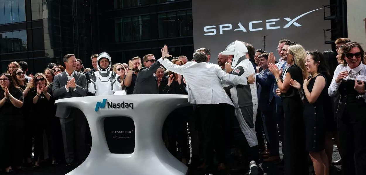 Membros da liderança da SpaceX e convidados comemoram IPO na Nasdaq.
