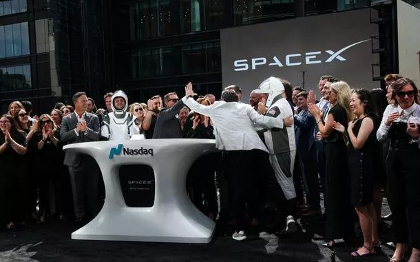 Membros da liderança da SpaceX e convidados comemoram IPO na Nasdaq.

