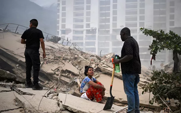 Mulher chora enquanto pessoas procuram por vítimas em meio aos escombros deixados pelos terremotos na Venezuela